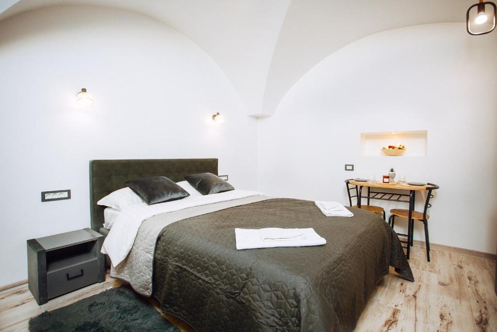 Un dormitorio con una cama grande y una mesa. en Balcescu Residence, en Brasov