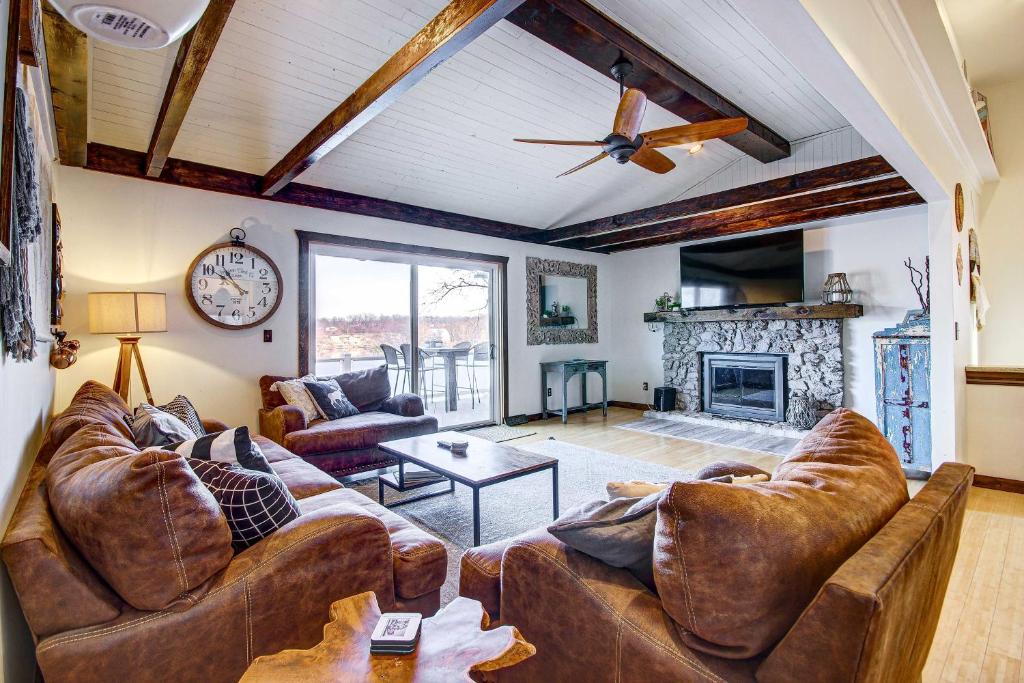 a living room with leather furniture and a fireplace at Lake Ozark Vacation Home with Hot Tub and Dock! in Lake Ozark