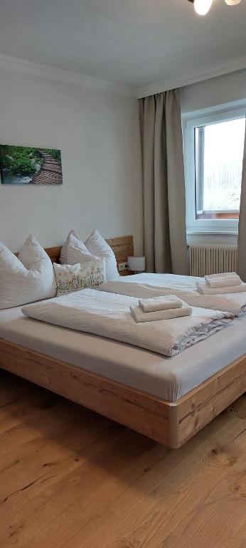 un grande letto in legno in una camera da letto con finestra di Schobermühle a Scharnstein