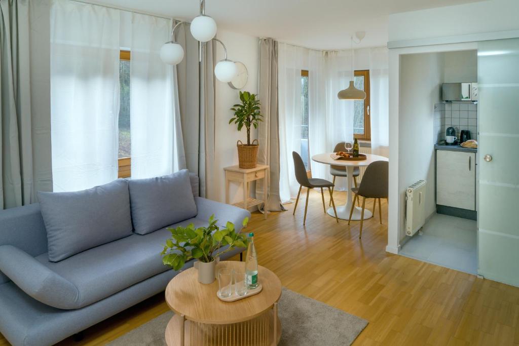 uma sala de estar com um sofá azul e uma mesa em NEW-Rita - atemberaubenden Wasserfälle em Triberg
