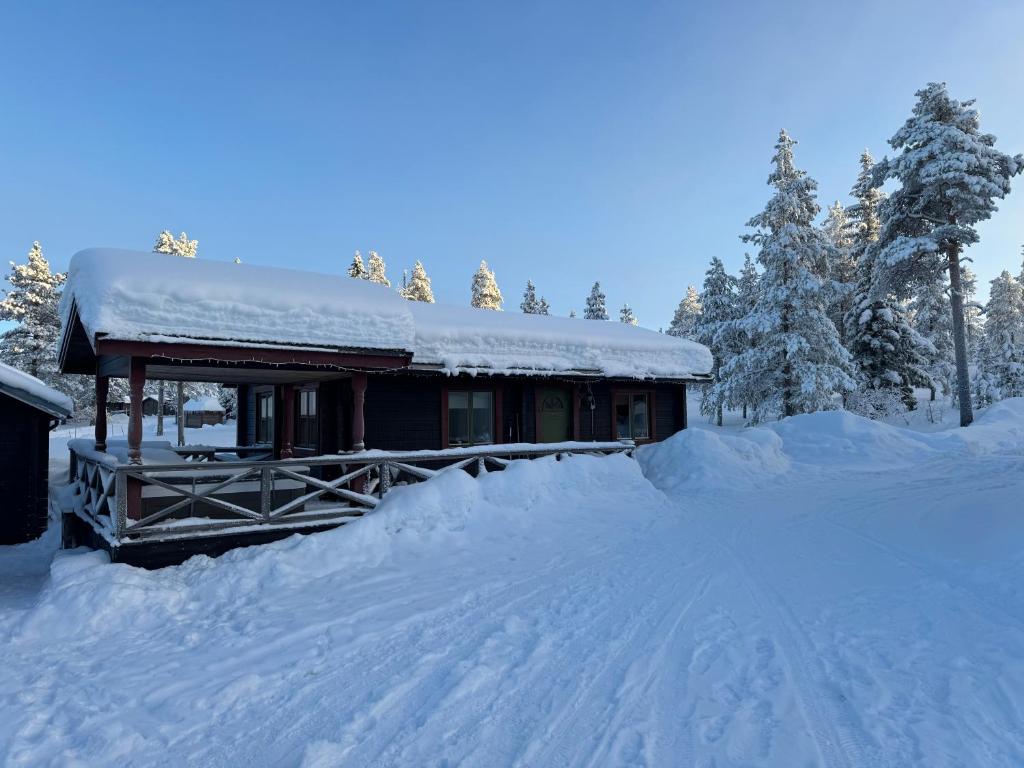 a house covered in snow with a pile of snow at Joy Stugan Näsfjället in Sörsjön