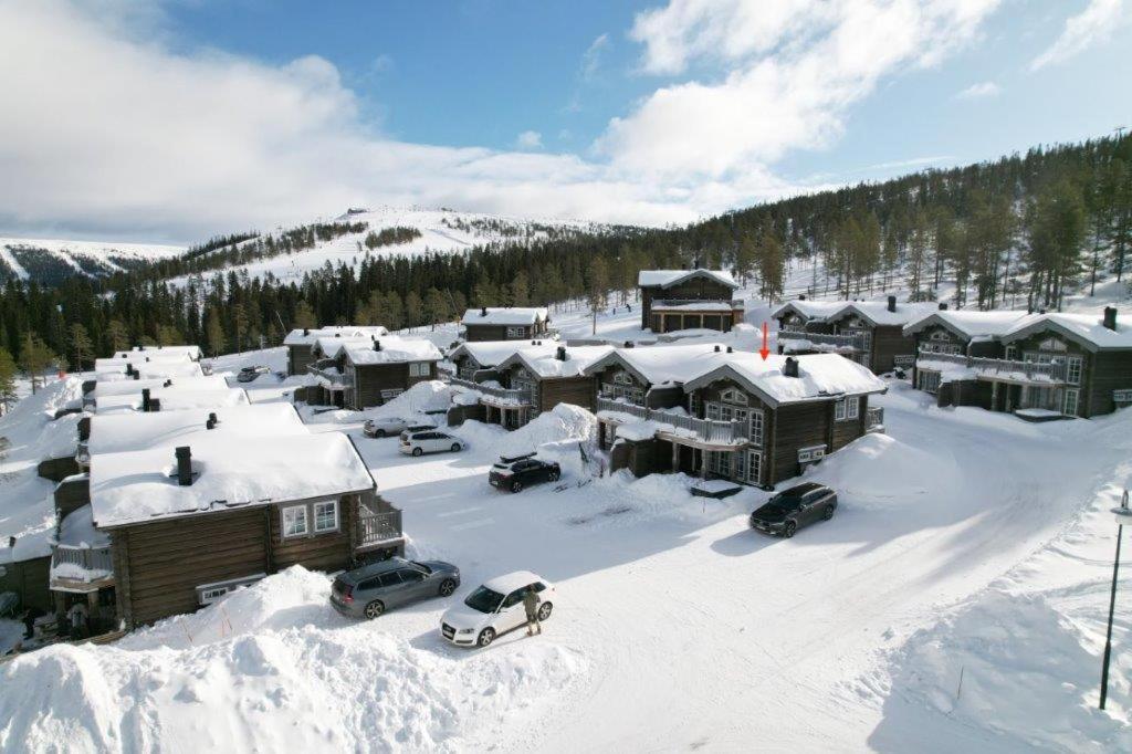 a snow covered village with cars parked in the snow at Exklusiv ski in-ski out stuga, i Hundfjället Sälen in Sälen