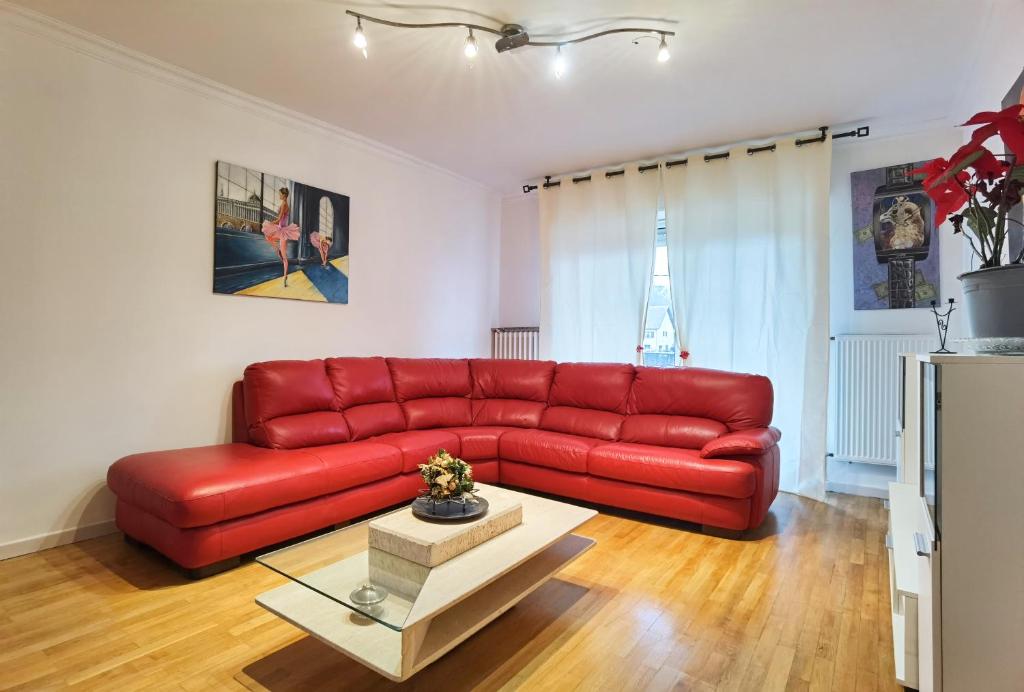 - un canapé rouge dans le salon avec une table dans l'établissement Maison à la campagne, à Béning-lès-Saint-Avold