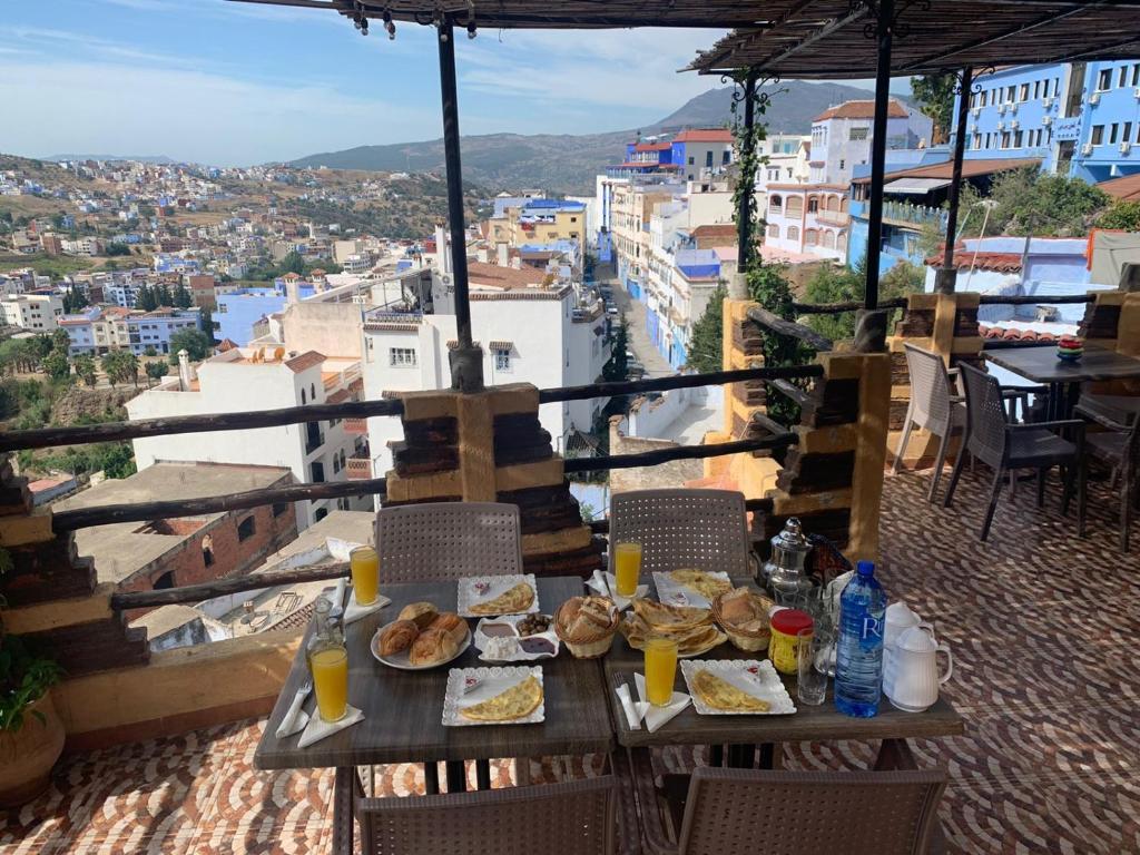 a table with plates of food on top of a city at dream house sebanine in Chefchaouene