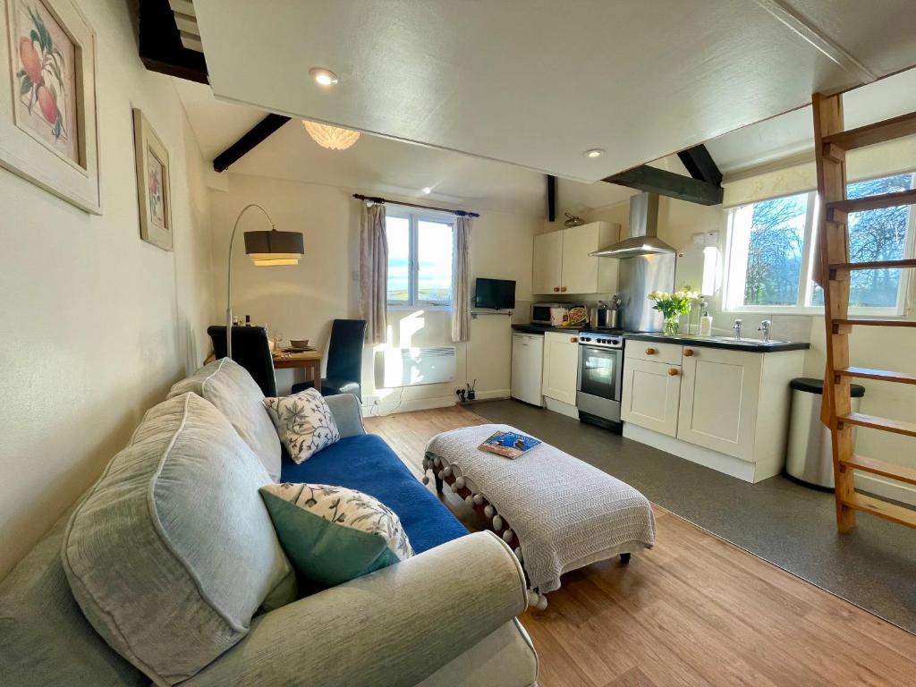 a living room with a blue couch and a kitchen at The Granary in Braunton