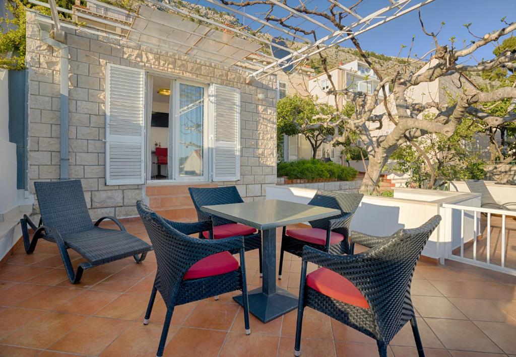 um pátio com uma mesa e cadeiras num alpendre em Apartment Cable car 1 em Dubrovnik