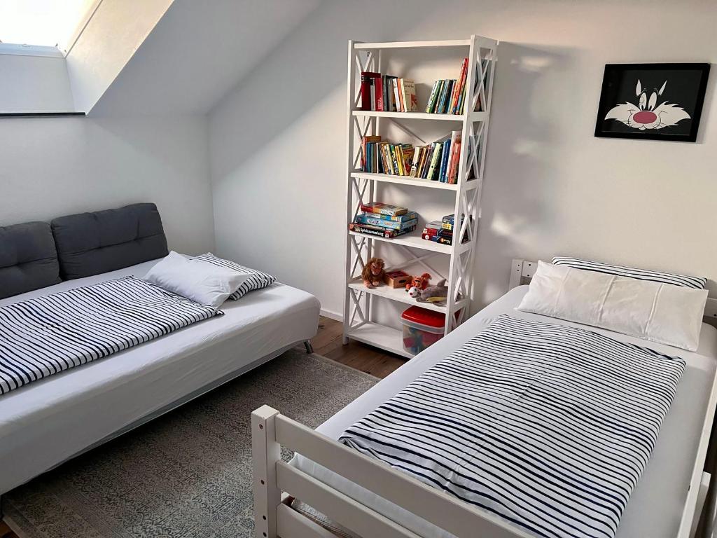 une chambre avec deux lits et une étagère dans l'établissement FERIENWOHNUNG SEEBRISE mit sonniger Dachterrasse, à Uhldingen-Mühlhofen