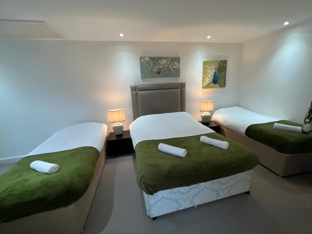 a room with two beds and a couch at Fulham suites in London