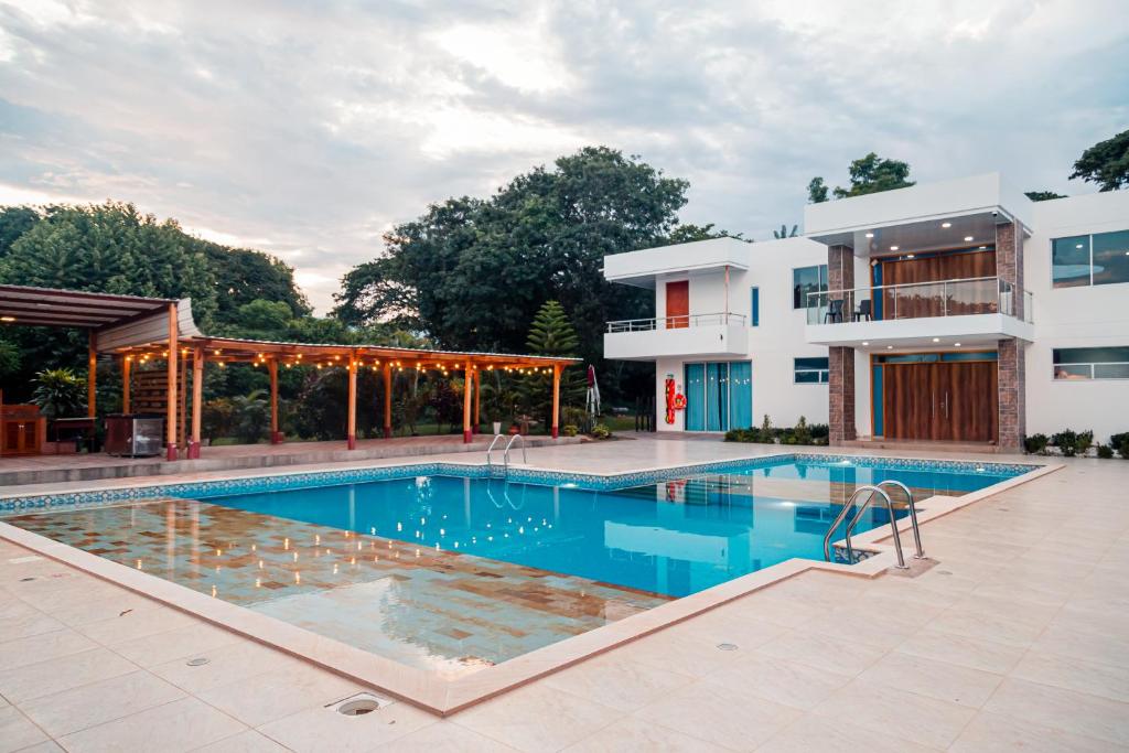 a swimming pool in front of a house at Casa Campo Victoria in Valledupar