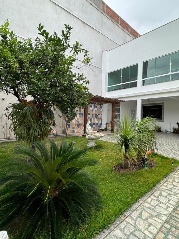 ein Gebäude mit einem Innenhof mit Pflanzen davor in der Unterkunft Residencial Vilaça in Guarapari