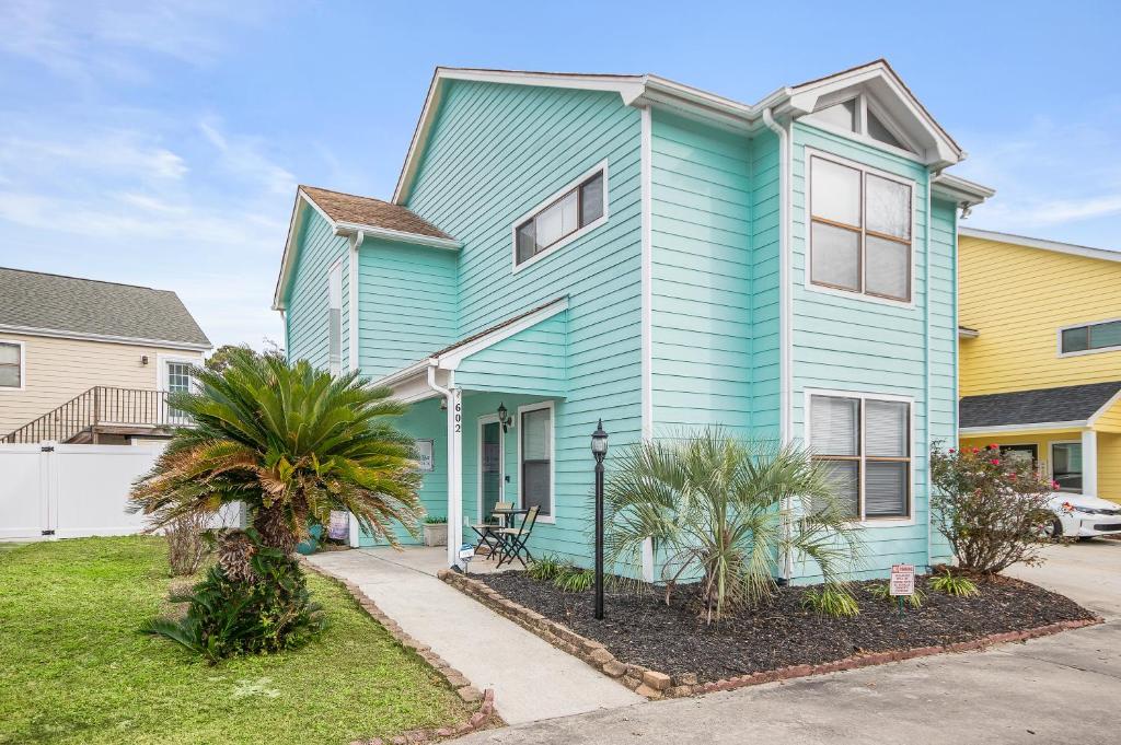 a blue house with palm trees in front of it at ONE More Happy Day 3BR-3BA Beach House w-HotTub, Sleeps 11 in Myrtle Beach