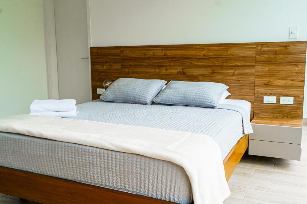 a bedroom with a large bed with a wooden headboard at Luxury Apartments estilo New York in Guayaquil