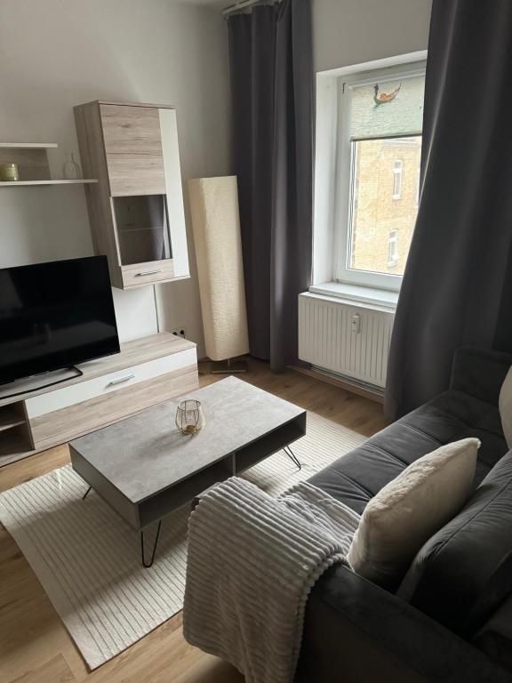 a living room with a couch and a table at Gemütliches Appartement "Franz" in Halle in Rusches Hof