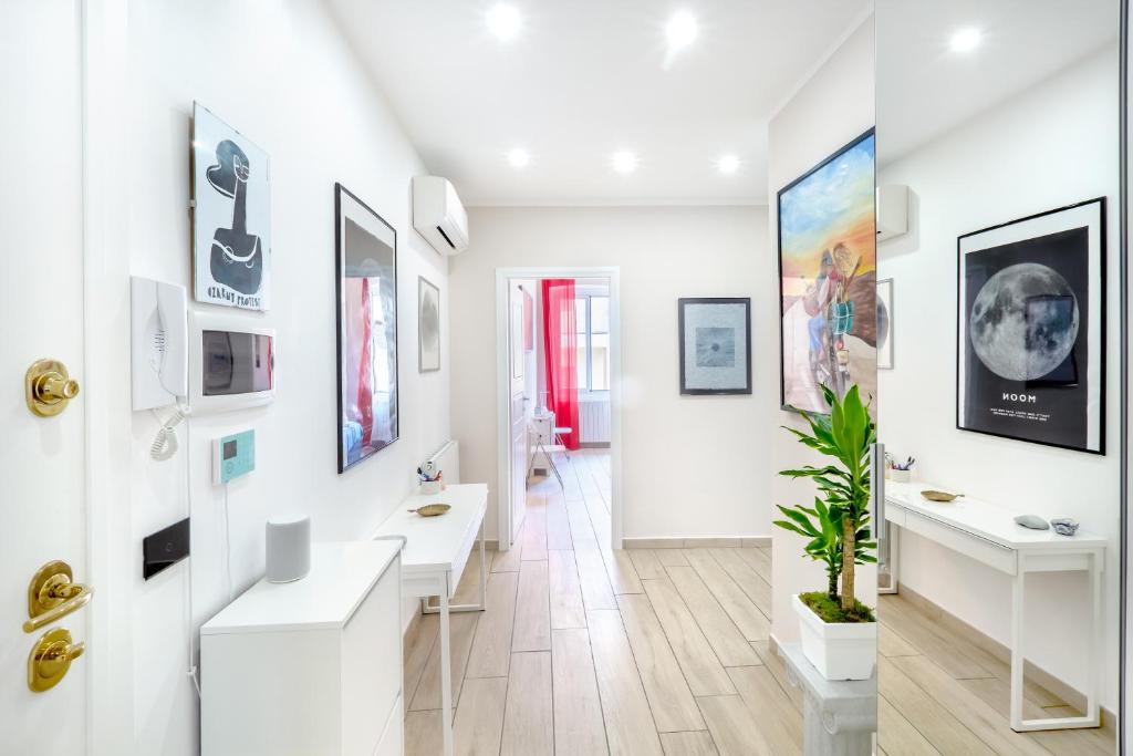 um quarto branco com secretárias brancas e quadros nas paredes em Waterfront District Apartment em Gênova