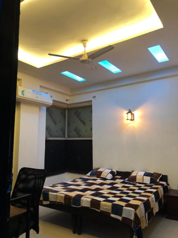 a bedroom with a bed and a ceiling fan at StayHolic in Ghaziabad