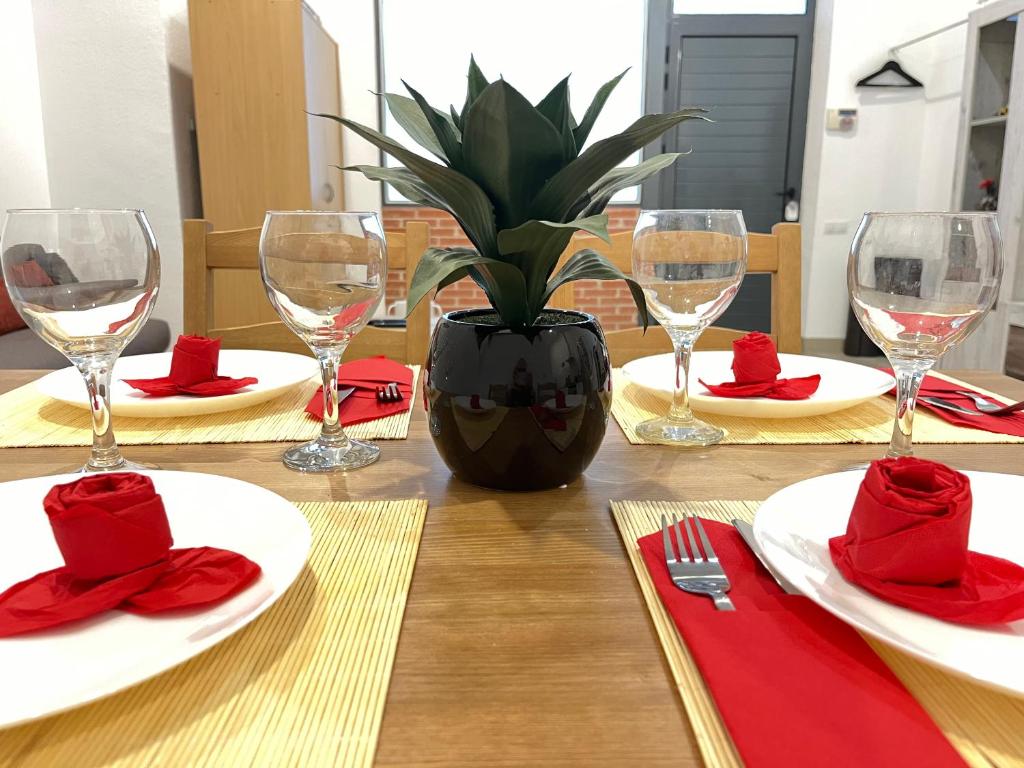 a table with red napkins and glasses and a potted plant on it at ☆The Central Valencia Stay☆ in Valencia