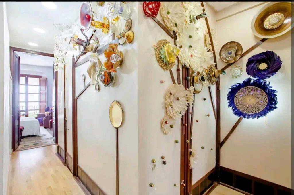 un corridoio con decorazioni sul muro in una casa di Jardin secreto en el centro de Barcelona 2 a Barcellona