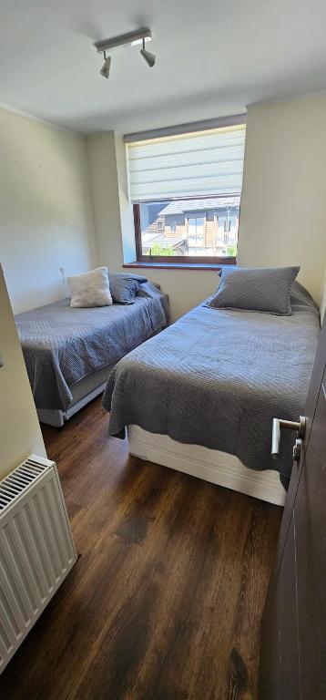Un dormitorio con dos camas y una ventana. en Bella casa en Costa Pucón, en Pucón