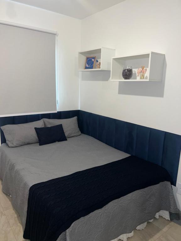 - un lit avec une tête de lit bleue dans une chambre dans l'établissement Studio na Orla, à Salvador