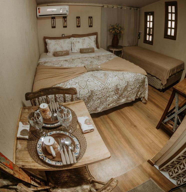 a bedroom with a bed and a table with a tray of food at Doce Lar Acomodações Noronha in Fernando de Noronha
