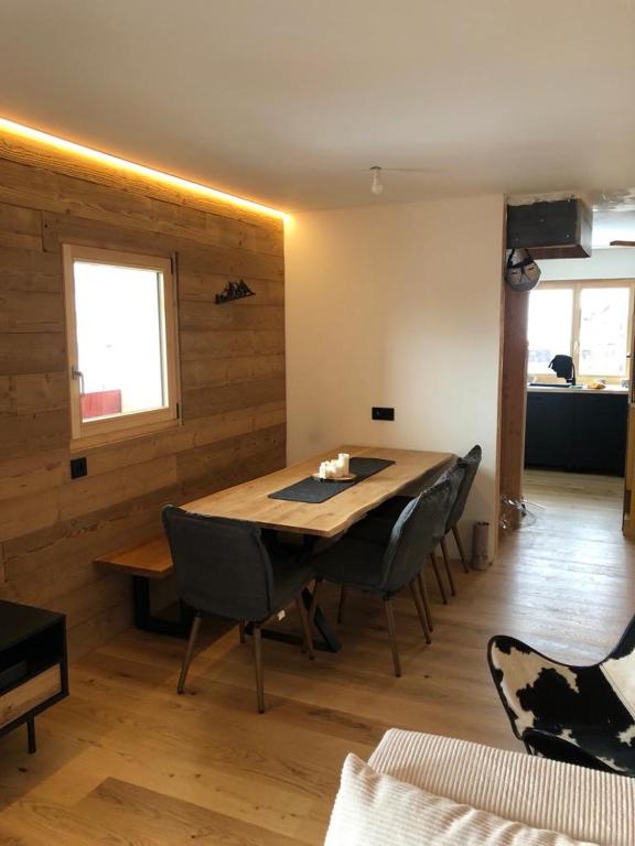 une salle à manger avec une table et des chaises en bois dans l'établissement Le Chappart, aux Carroz d'Arâches