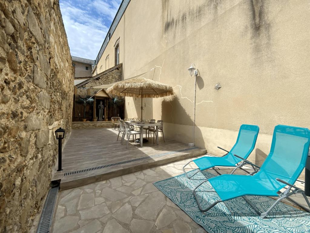- 2 chaises bleues et un parasol sur la terrasse dans l'établissement Junglissime - By BEST KEYS - Déco Jungle & Grand Patio Privé - 1 chambre séparée & 1 canapé convertible - Centre Ville - Smart TV - Machine à Café Nespresso - WiFi Fibre - Check-in Autonome - Parking Facile & Gratuit, à Sens