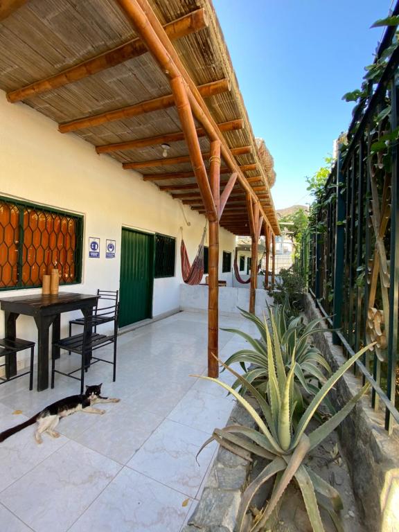 a patio with a wooden roof and a table at Hostal Acuarius in Taganga
