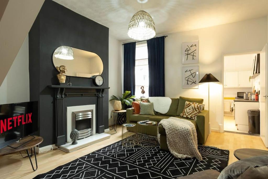 uma sala de estar com um sofá e uma lareira em NEW DEALS - Spacious, Stylish Home - Wi-Fi, Smart TV, Parking & Outdoor Area em Leicester