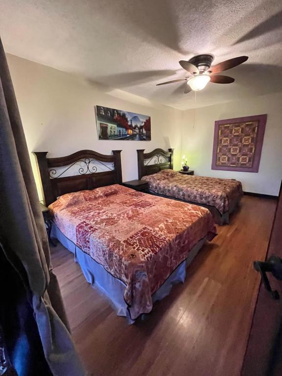 1 dormitorio con 2 camas y ventilador de techo en Casa Harding, en Guatemala