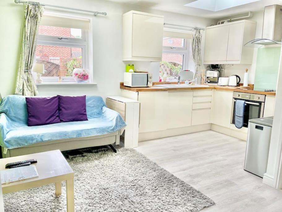 a living room with a blue couch in a kitchen at Entire Flat Free Parking Quiet Area *Self-Check In in Headingley
