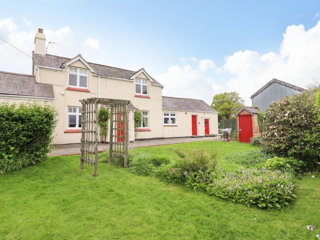 an exterior view of a house with a garden at Plas Cwtta in Clocaenog