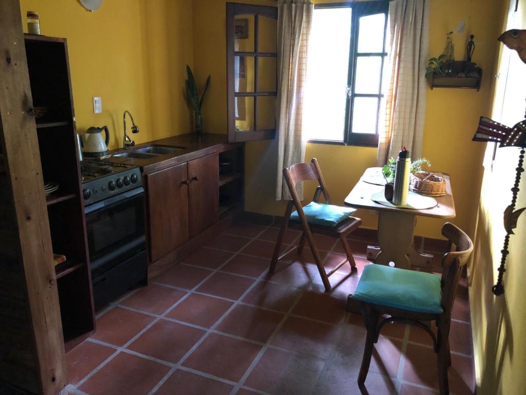 eine Küche mit einem Tisch und einem Herd Top-Backofen in der Unterkunft Prana Eco hospedaje in Cordoba