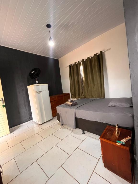 a bedroom with a bed and a small refrigerator at Chale do Japa in Sao Jorge