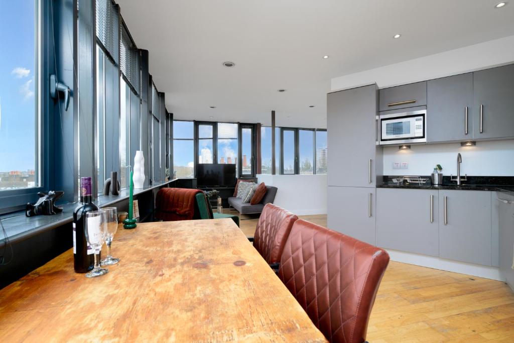 a kitchen and dining room with a wooden table and chairs at Luxury Central London Penthouse in London