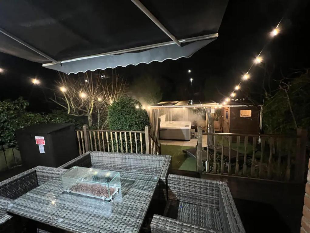a table and chairs on a patio at night at Freeman Hot Tub House, Free Parking, Transport Links in Longbenton