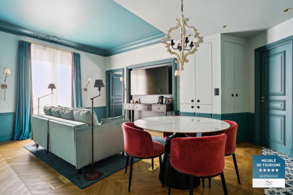 une salle à manger avec une table, des chaises et un canapé dans l'établissement Séjours Parisiens - Suites Haussmann, Malesherbes & Madeleine, à Paris