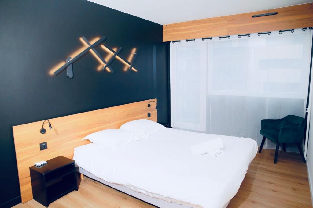 1 dormitorio con cama blanca y pared negra en Alison's Suite, en Thonon-les-Bains