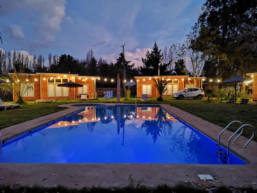 a swimming pool in front of a house at night at Rukawe Quillon in Quillón