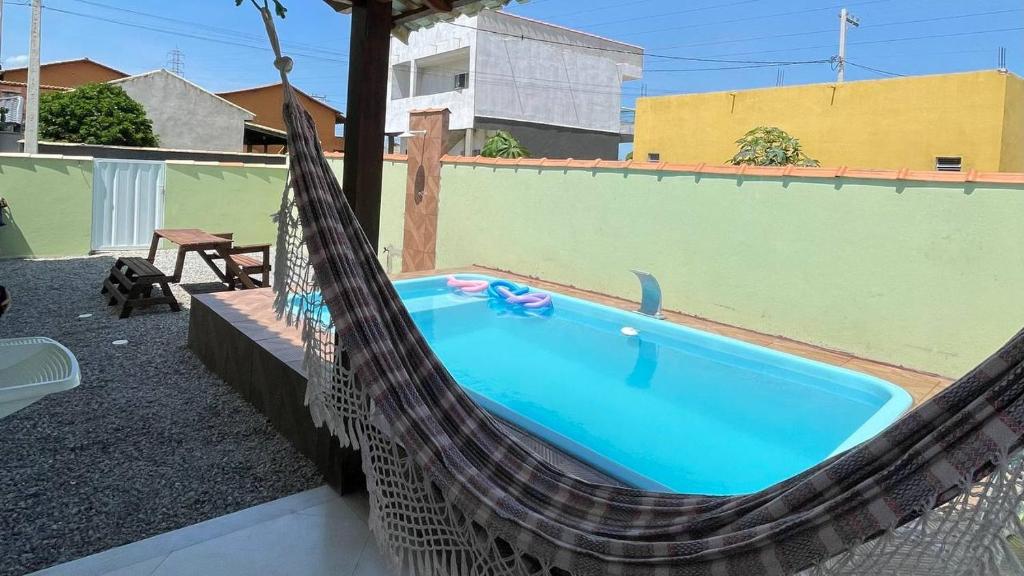 una hamaca alrededor de una piscina en el patio trasero en Casa Unamar en Cabo Frío