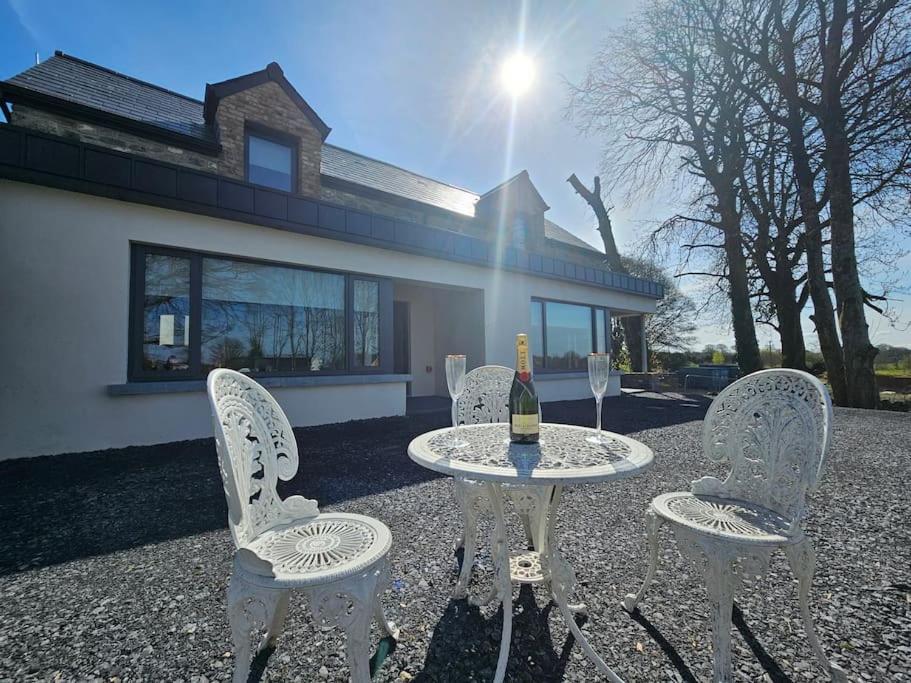 - une table et trois chaises avec une bouteille de vin dans l'établissement Private House in Oldcastle, à Oldcastle