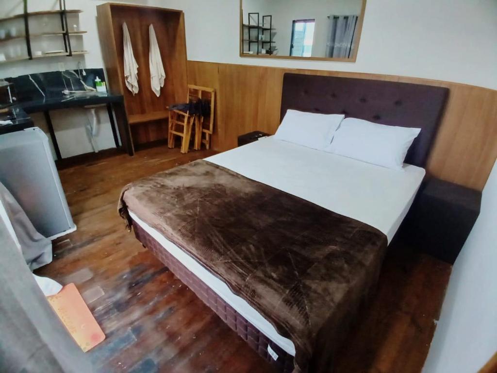 a bedroom with a large bed with a wooden floor at Patiño Lodge in Itauguá