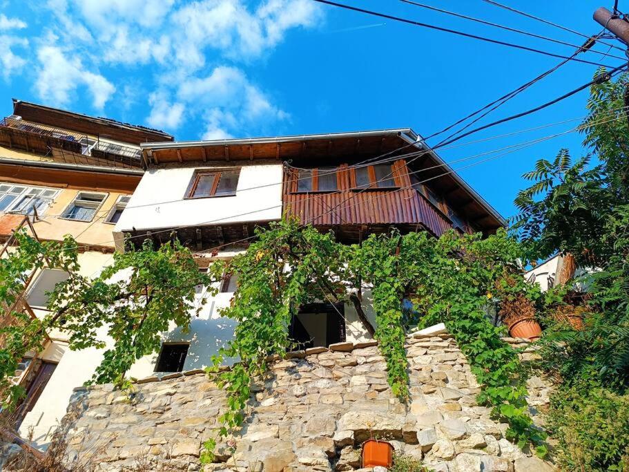 a building with vines growing on the side of it at Bobevata guest house - Floor 2 - Stunning view Old town in Veliko Tŭrnovo