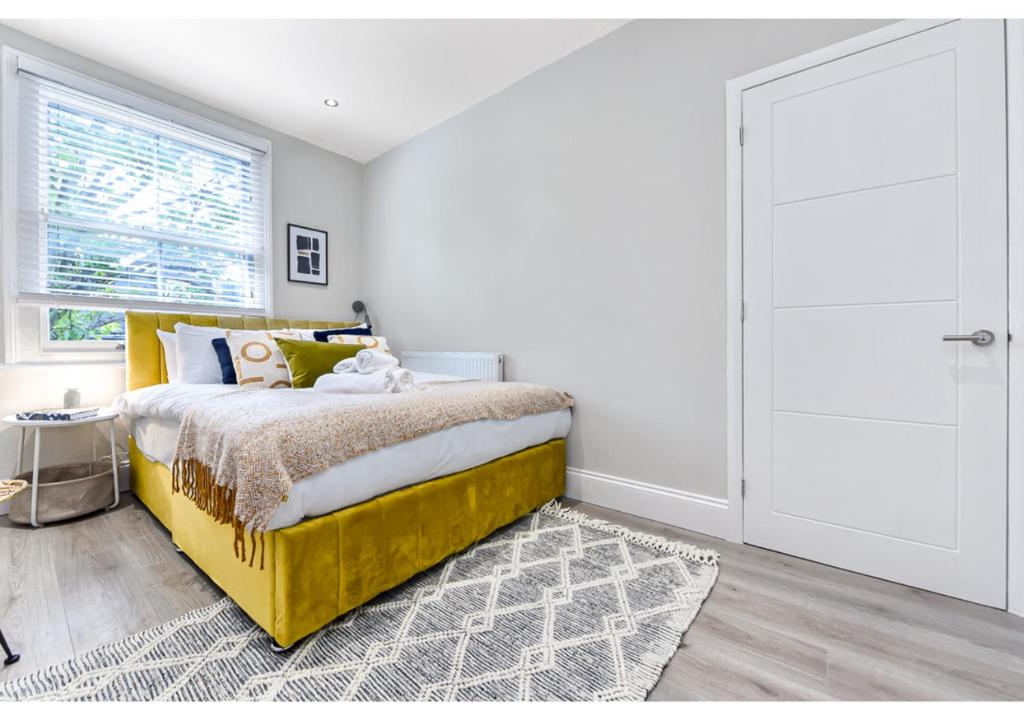 ein Schlafzimmer mit einem gelben Bett und einem Fenster in der Unterkunft New and Modern flat in London! in London