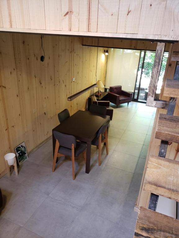 a table and chairs in a room with wooden walls at Departamento Cameron - Salepatagonia in San Martín de los Andes