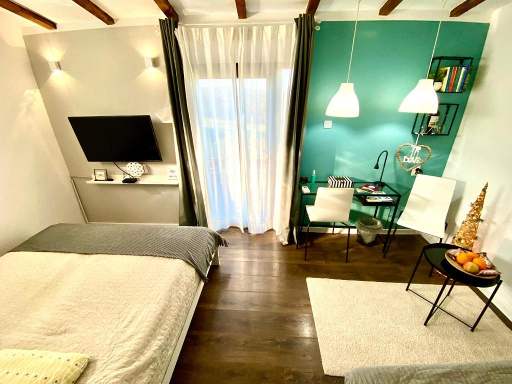 a bedroom with a bed and a dining room with a table at Avala Sunset Apartments in Belgrade