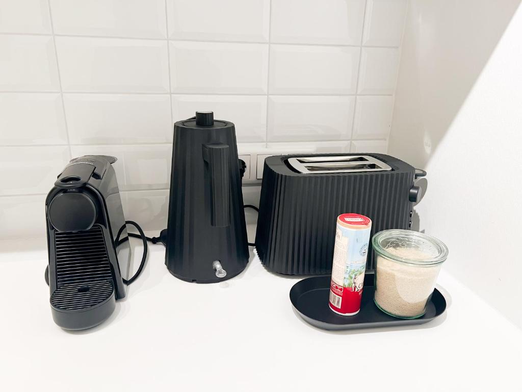a coffeemaker and a toaster sitting on a counter at Suite One Einsteinstraße in Munich