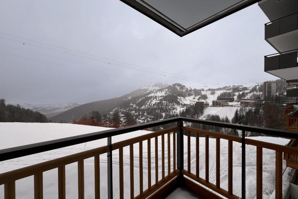 uma varanda com vista para uma montanha coberta de neve em Pretty cocoon overlooking the slopes em La Plagne Tarentaise