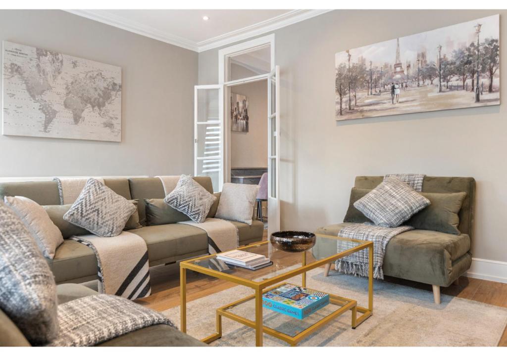 a living room with two couches and a coffee table at Chic & Radiant Retreat in Harringay Ladder in London