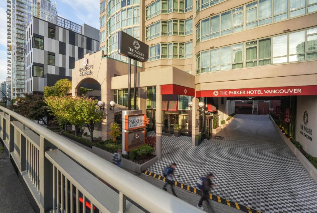 duas pessoas a andar numa rua em frente a um edifício em The Parker Hotel Vancouver em Vancouver