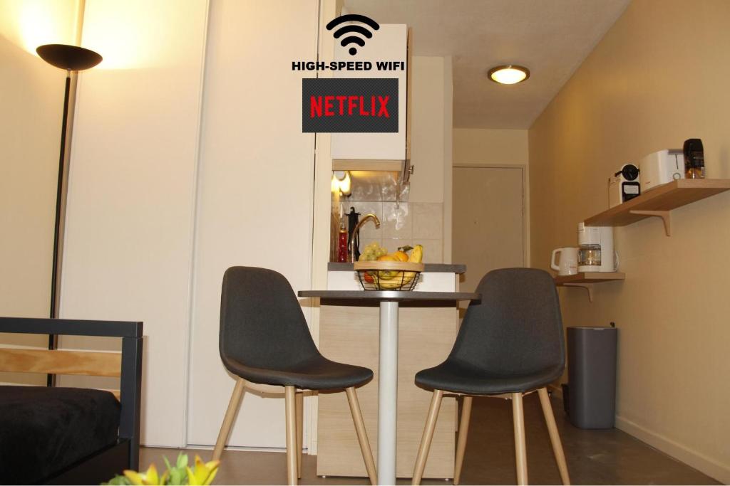 a kitchen with two chairs and a table with a sign at Grenoble hyper-centre + WiFi + Netflix in Grenoble